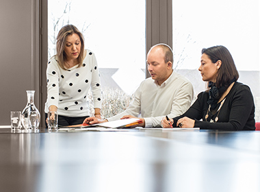 Three members of staff at Christiansen Print in discussion at a table.